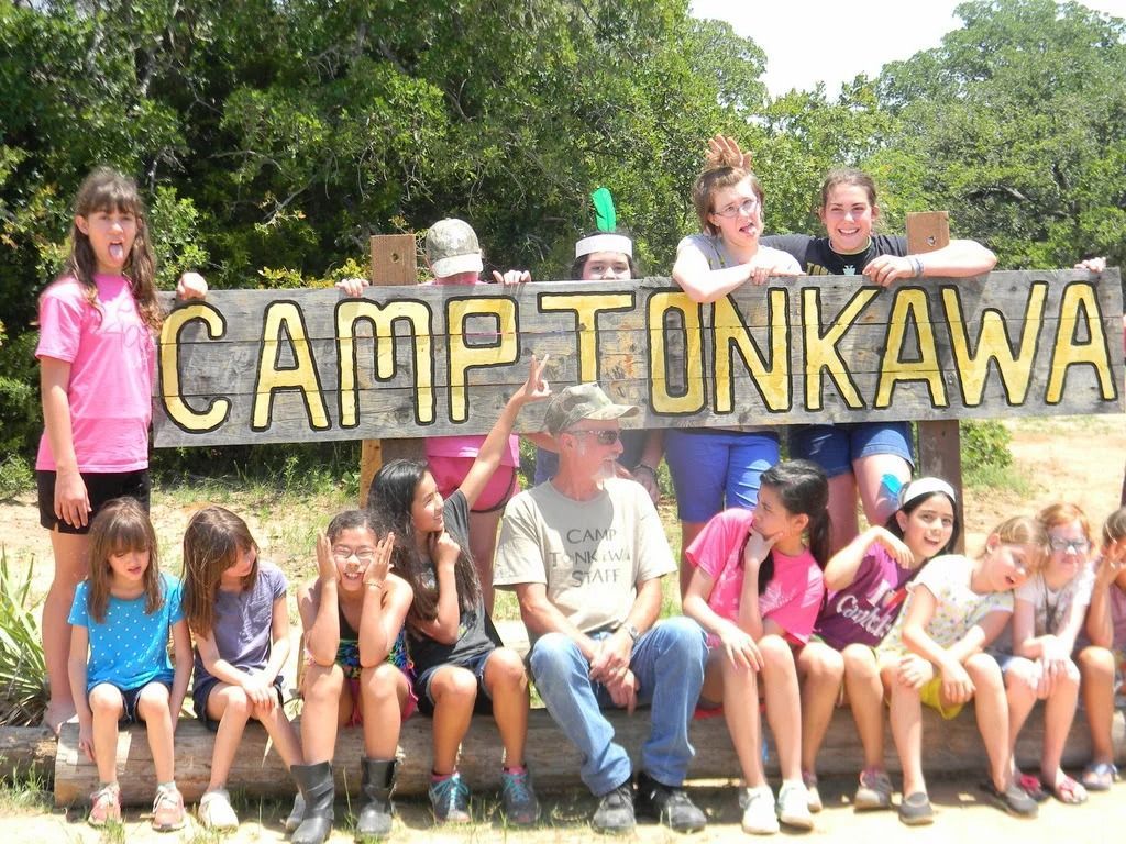 Group of campers posing in front of a “Camp Tonkawa” sign outdoors