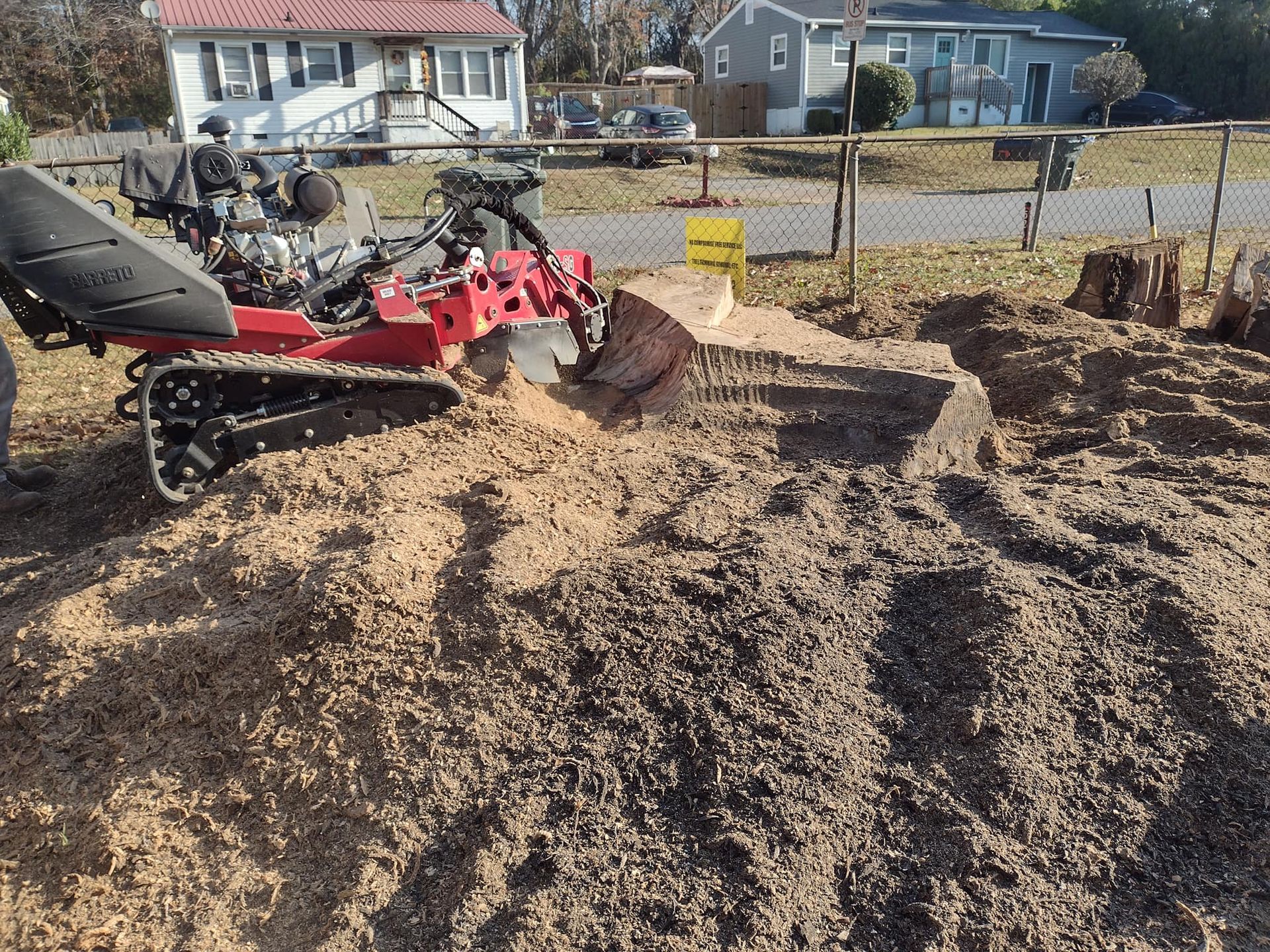 A person is using a tractor to remove a tree stump.