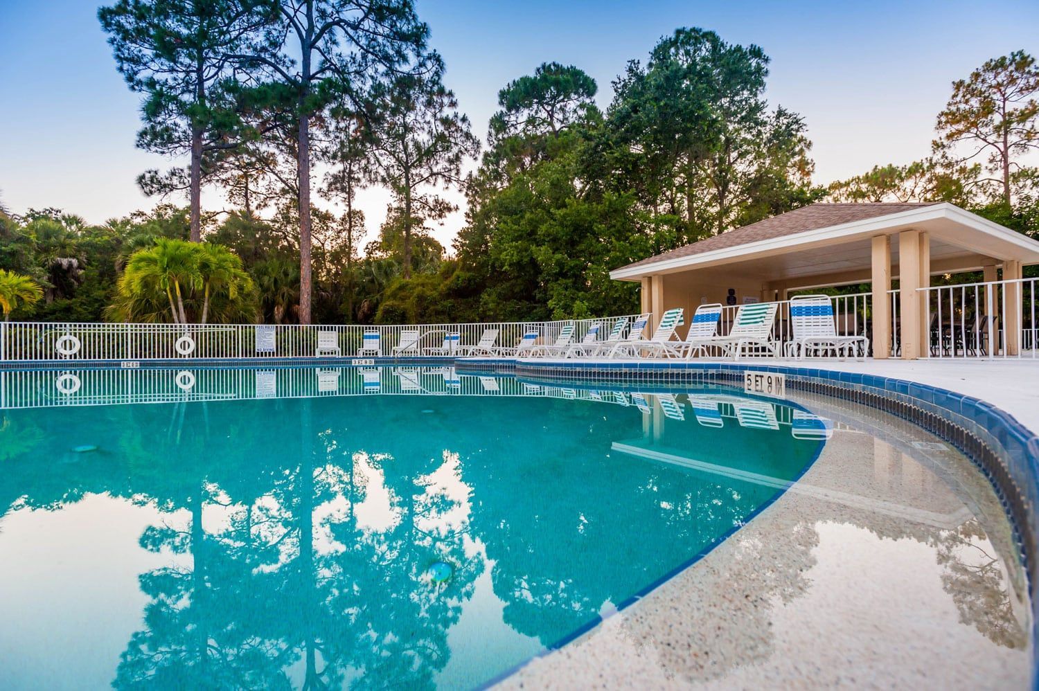 A large swimming pool with a gazebo in the background