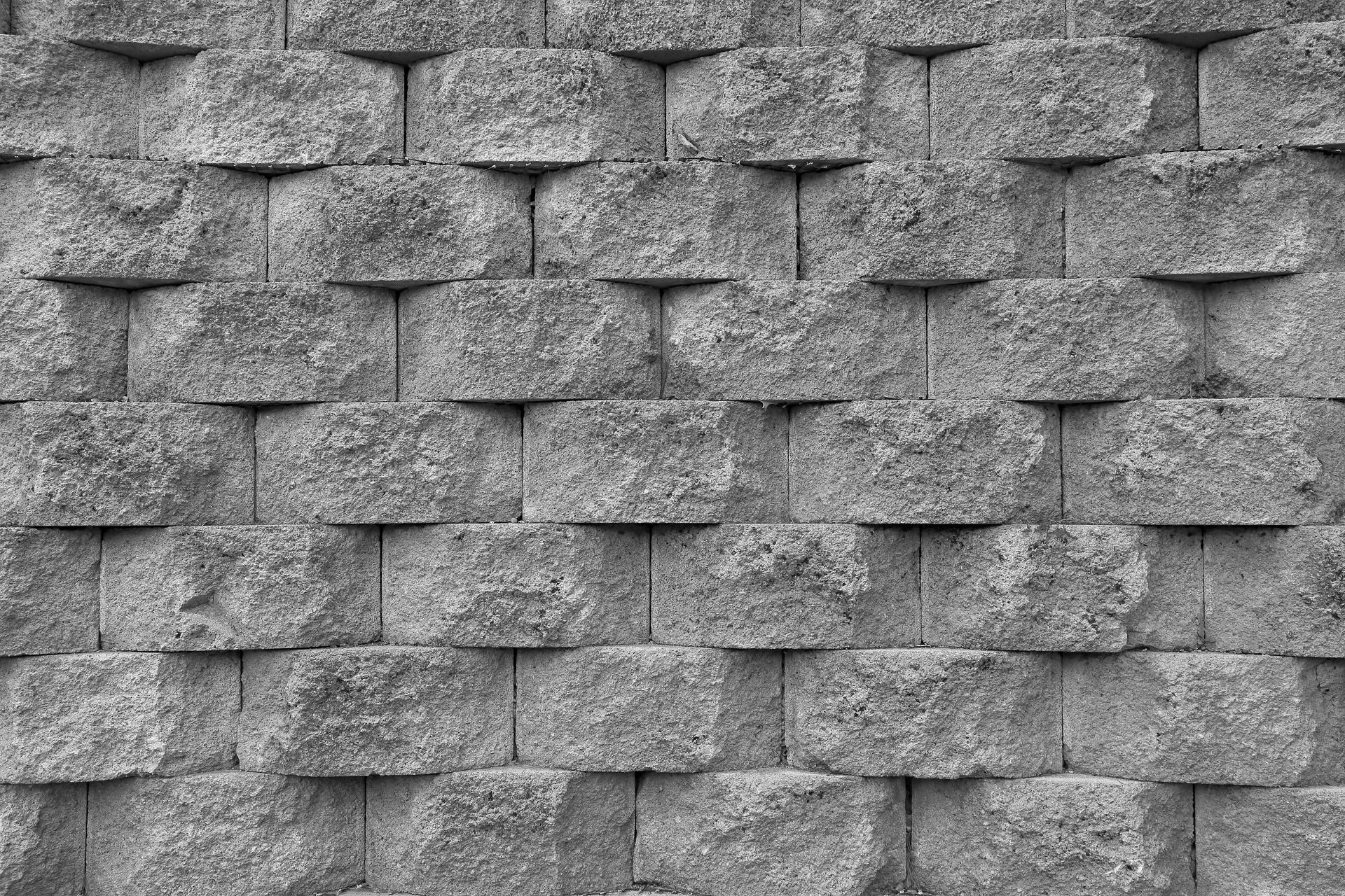 Gray textured stone wall pattern with overlapping shingle-like tiles
