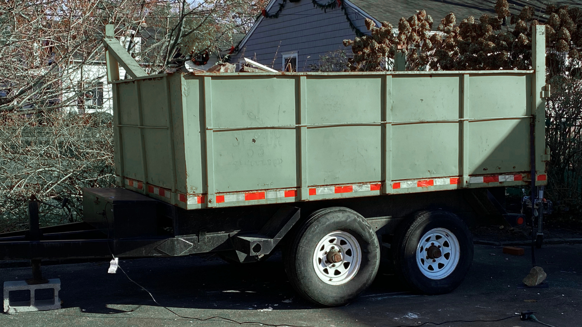 Residential cleanup project with dumpster placed in suburban driveway