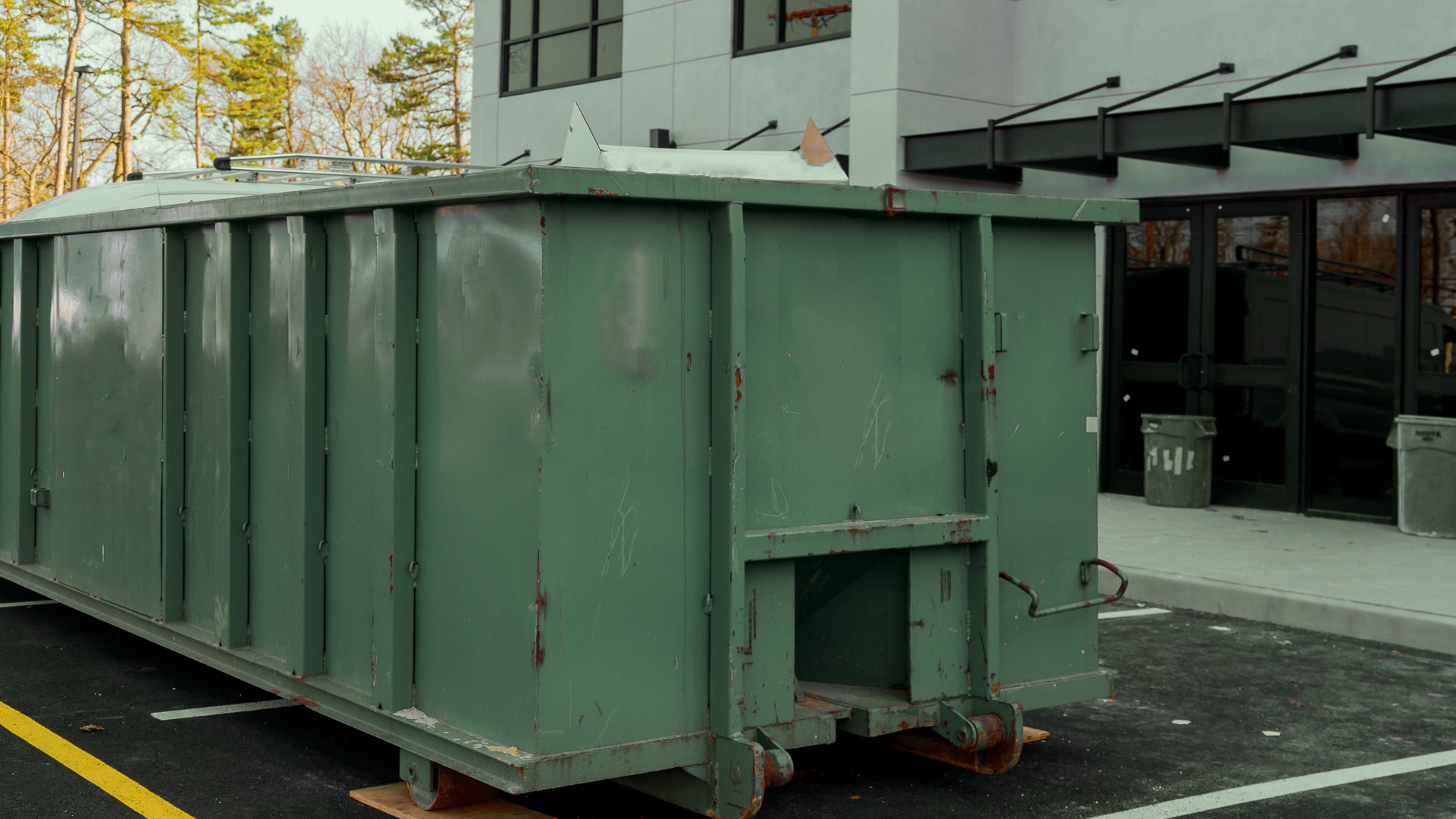 Construction waste being loaded into heavy duty dumpster container