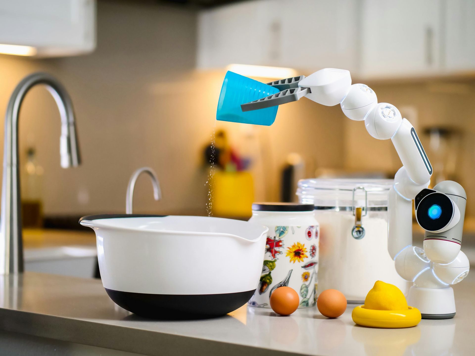 A robotic arm is reaching for something in a kitchen.