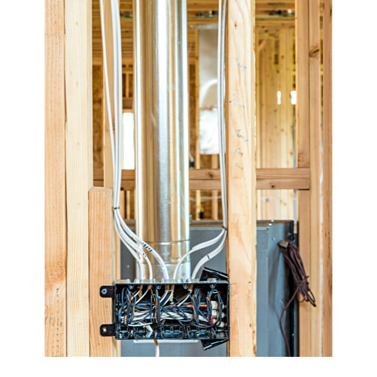 A house is being built with a lot of wires coming out of it.