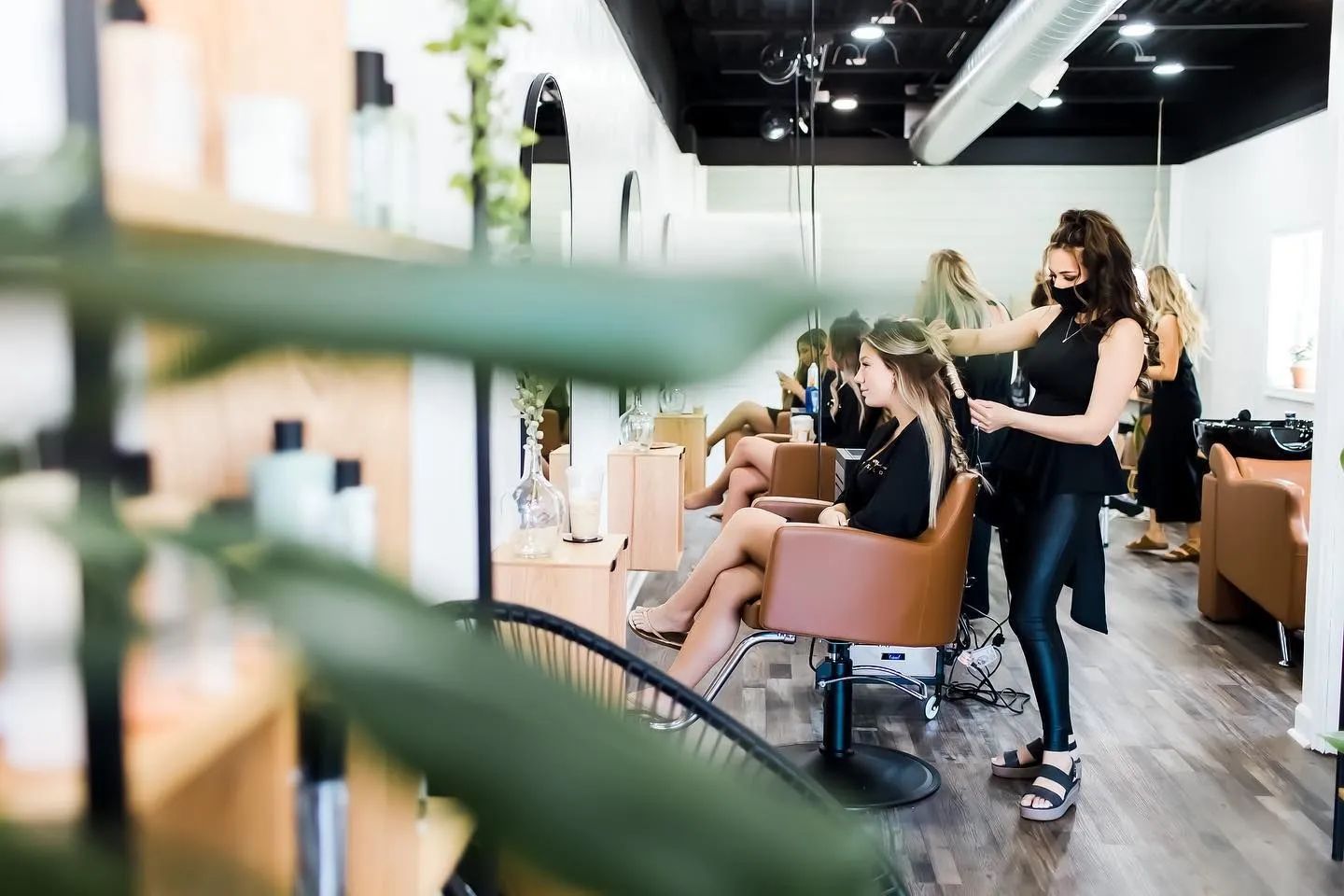 Stylists cutting and styling clients in a bright modern hair salon