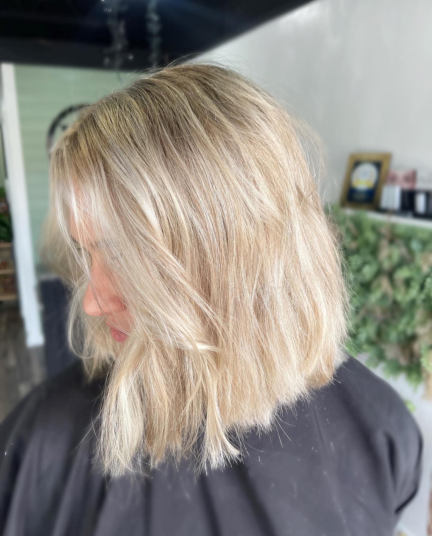 Blonde hair in a salon setting, shoulder-length cut.