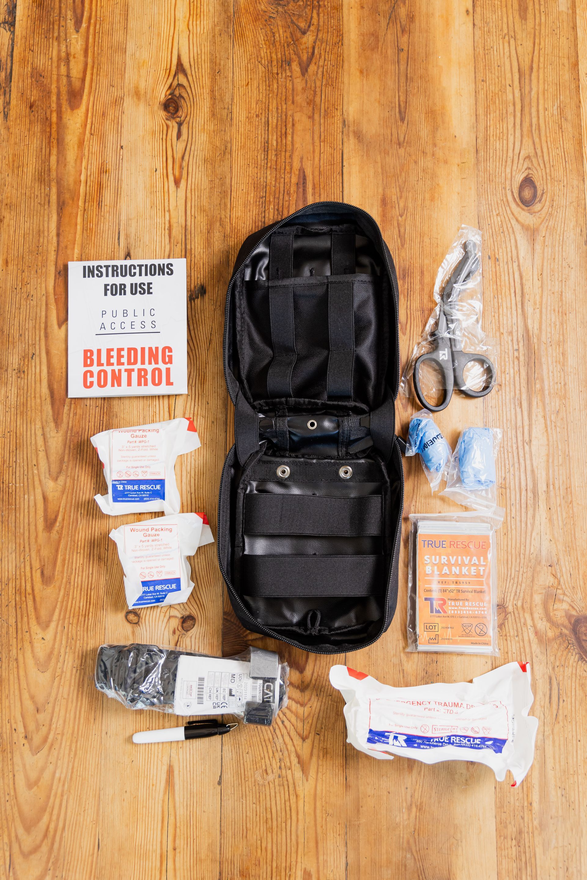 A first aid kit is sitting on top of a wooden table.