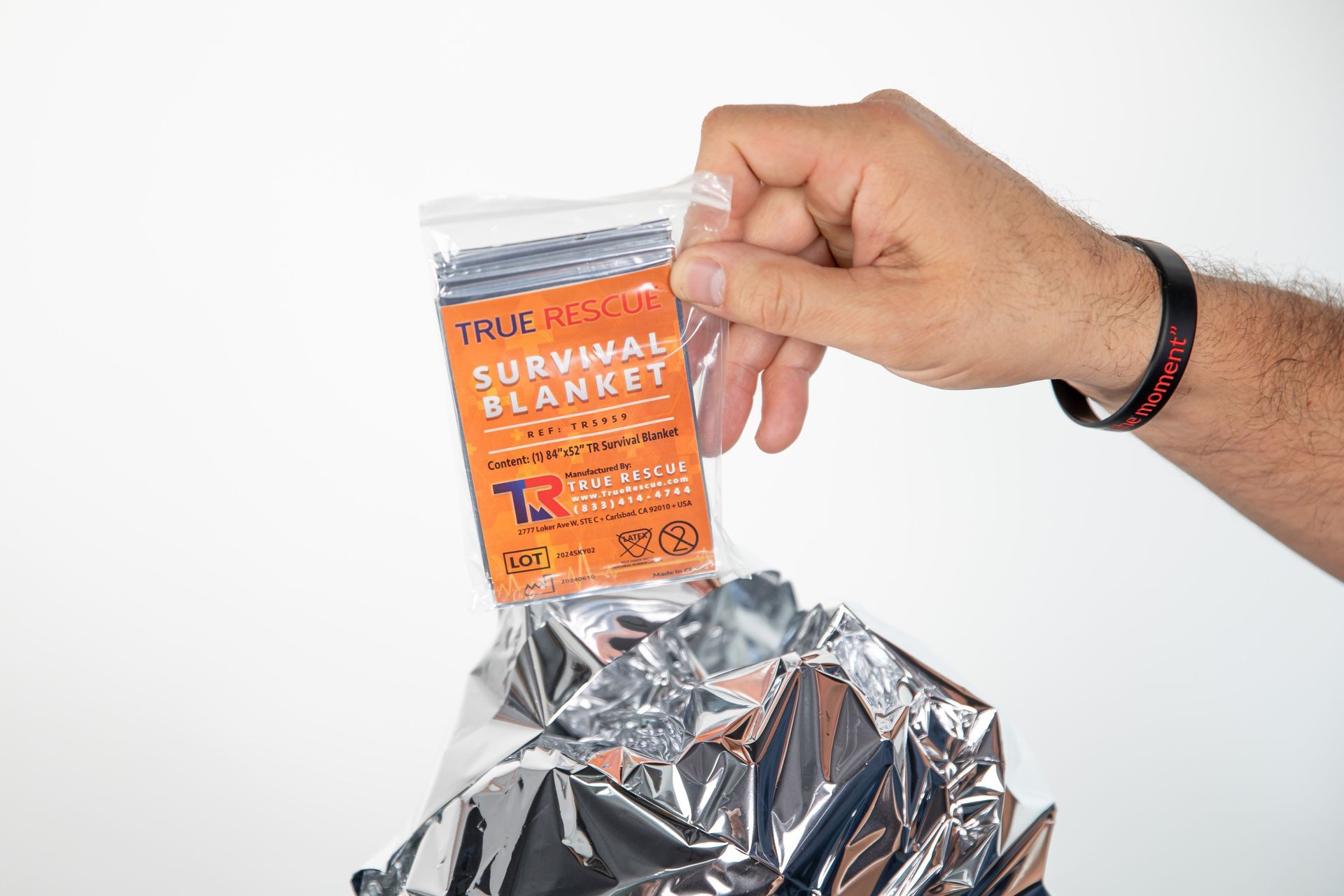 A person is holding a survival blanket in their hand.