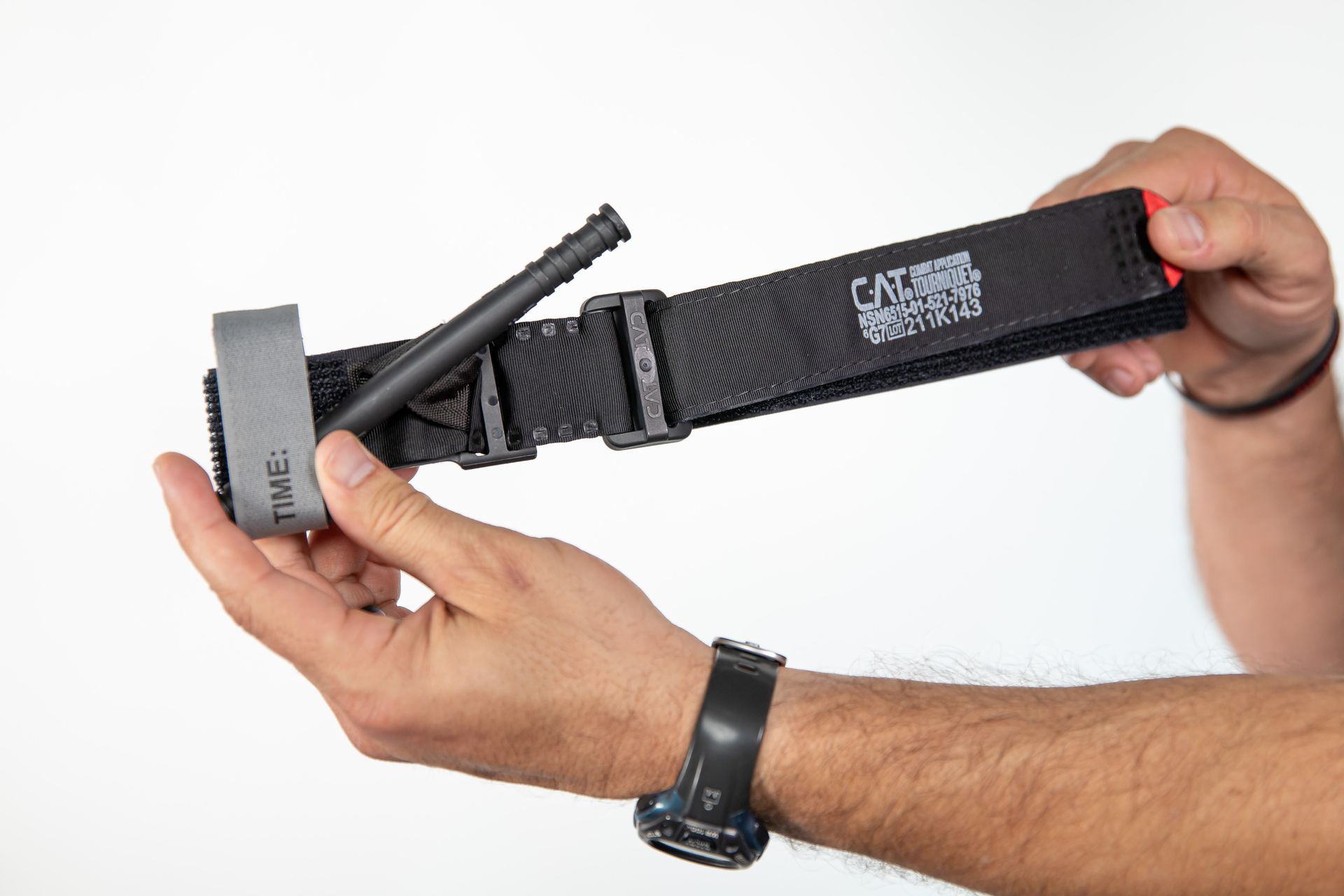 A person is holding a tactical tourniquet in their hands.