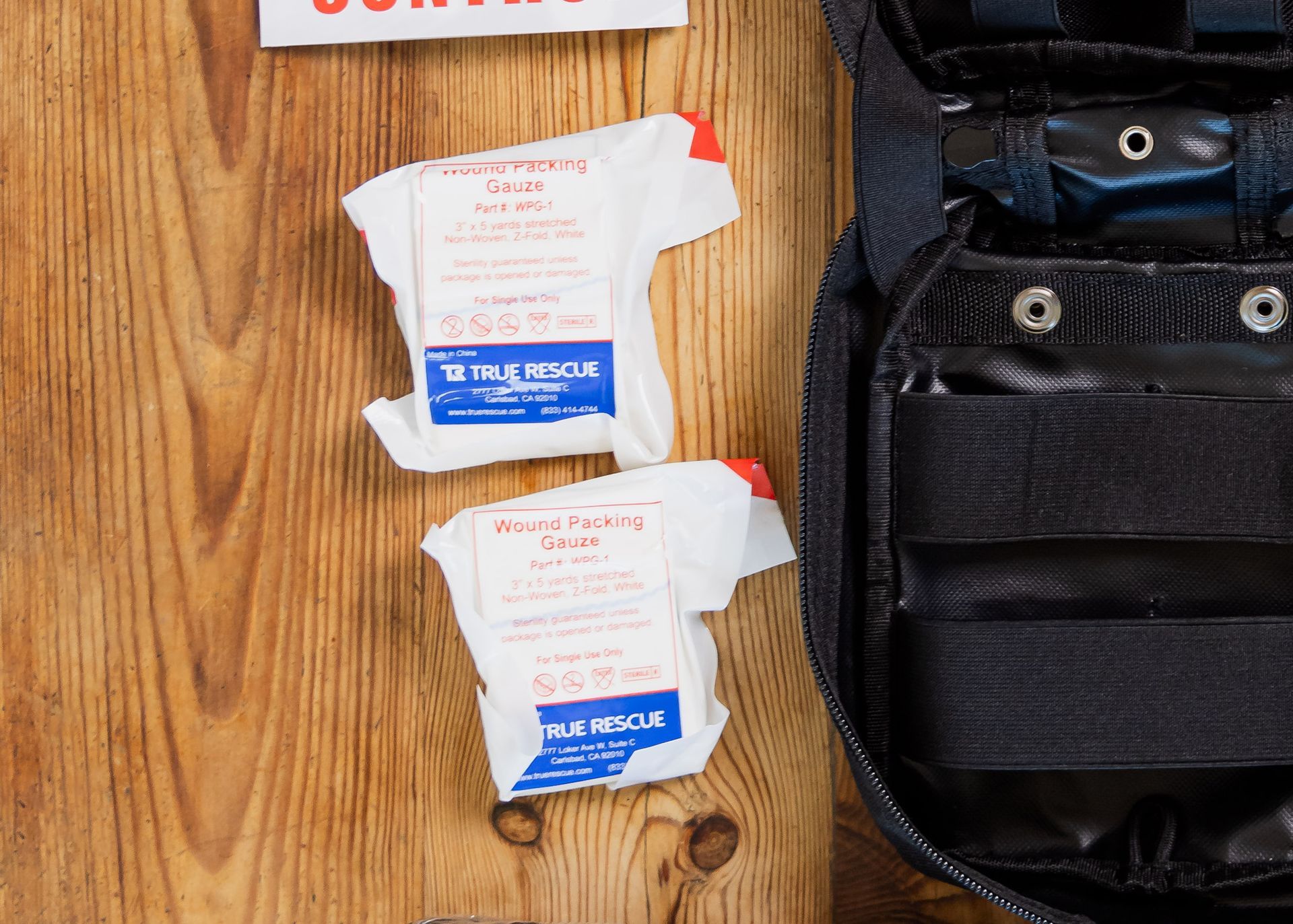 A first aid kit is sitting on a wooden table.