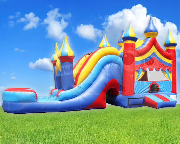Colorful inflatable bounce house with slide and turrets on a grassy field under a blue sky