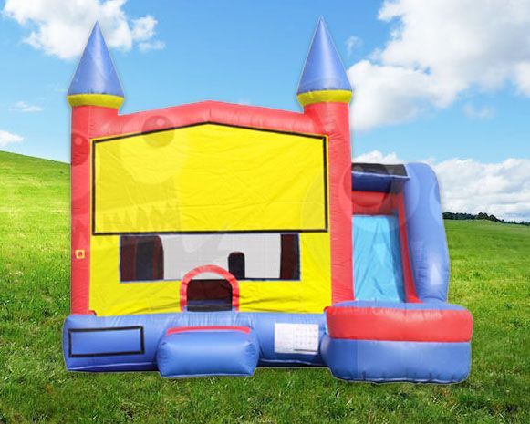 Colorful inflatable bounce house on grass with yellow front, blue slide, and castle turrets under a clear sky
