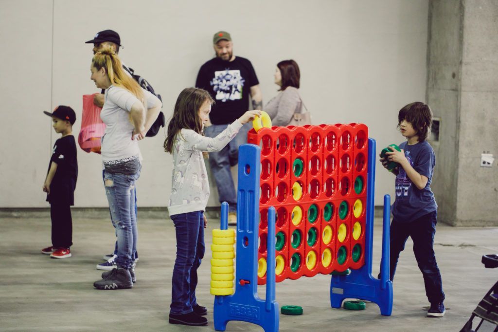 People playing giant Connect Four in a concrete indoor space