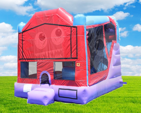 Red and purple inflatable bounce house on green grass under a blue sky