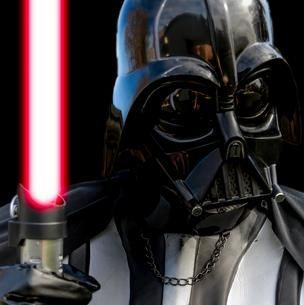 Darth Vader holding a red lightsaber against a black background