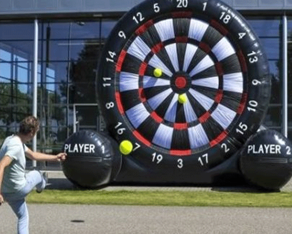 People playing giant outdoor dartboard game in front of a building