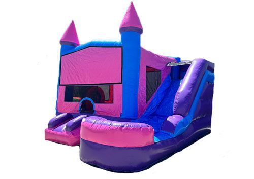 Pink and purple inflatable bounce house with slide and castle towers