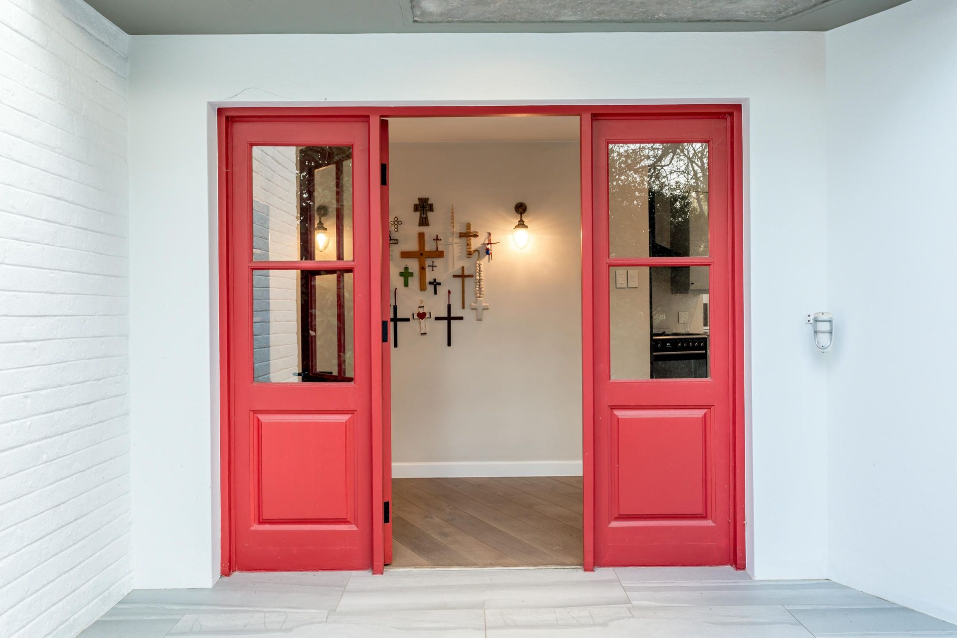 A red door is open to a white room