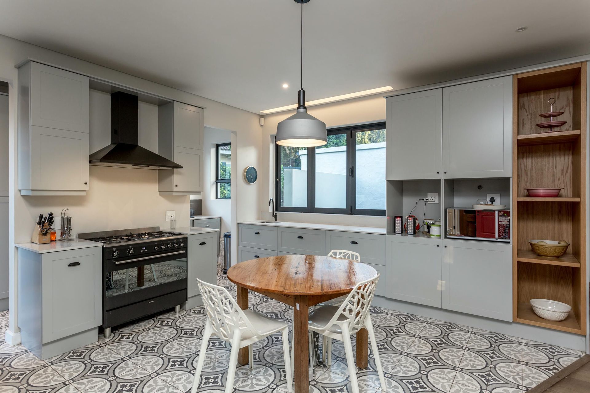 A kitchen with a table and chairs and a stove.