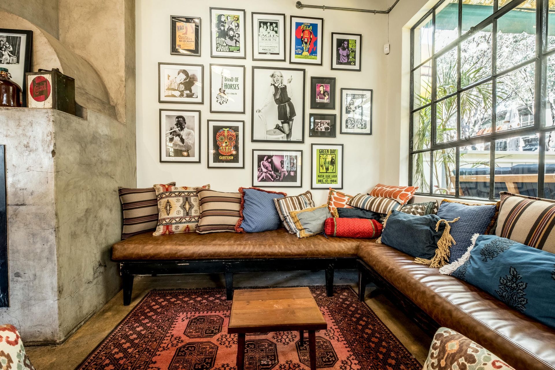 A living room with a couch , table , and pictures on the wall.