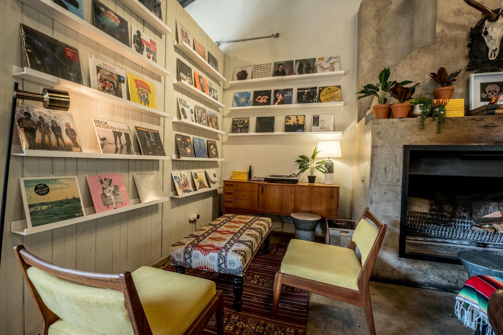 A living room with a fireplace and shelves filled with records.