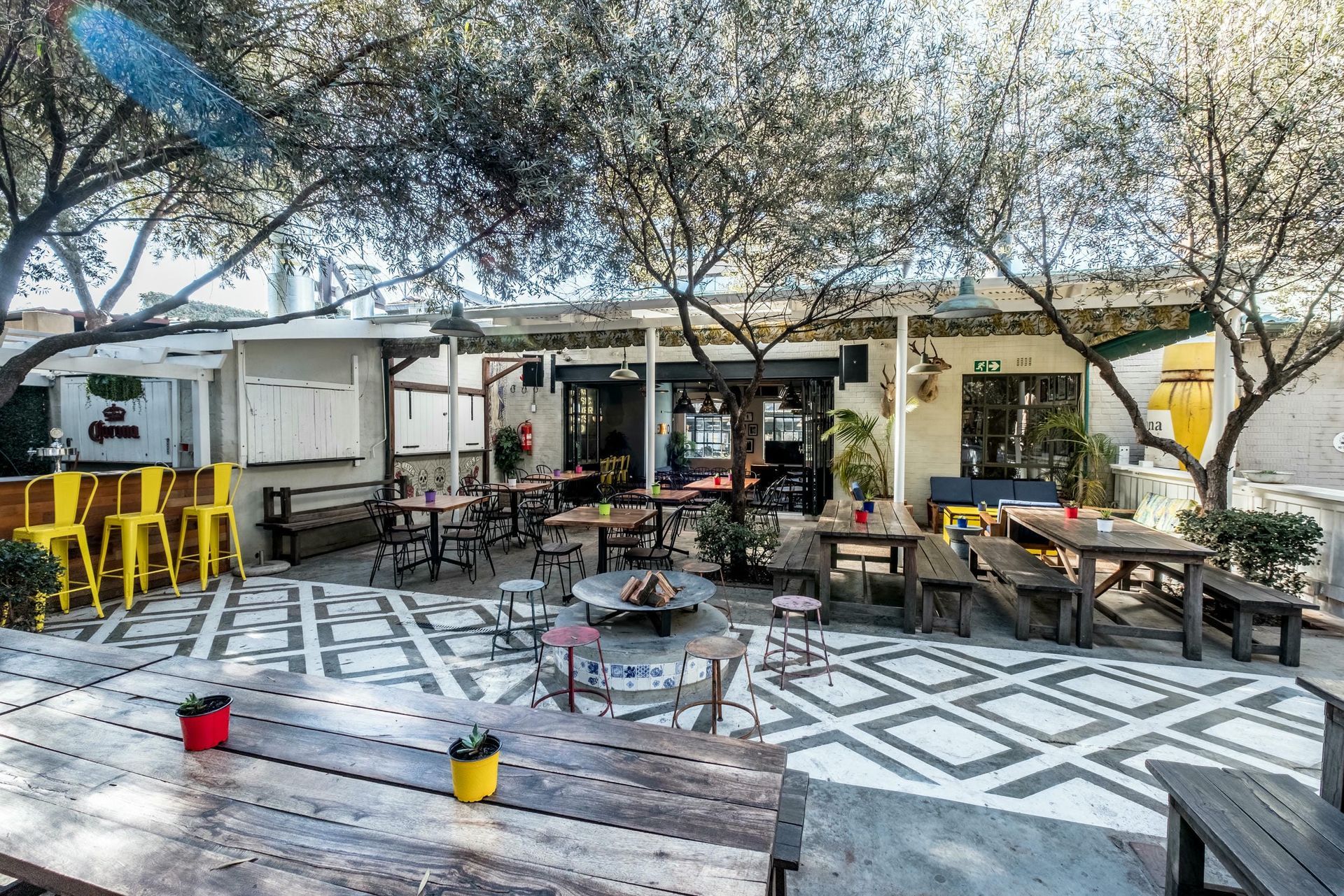 A restaurant with tables and benches in front of it.