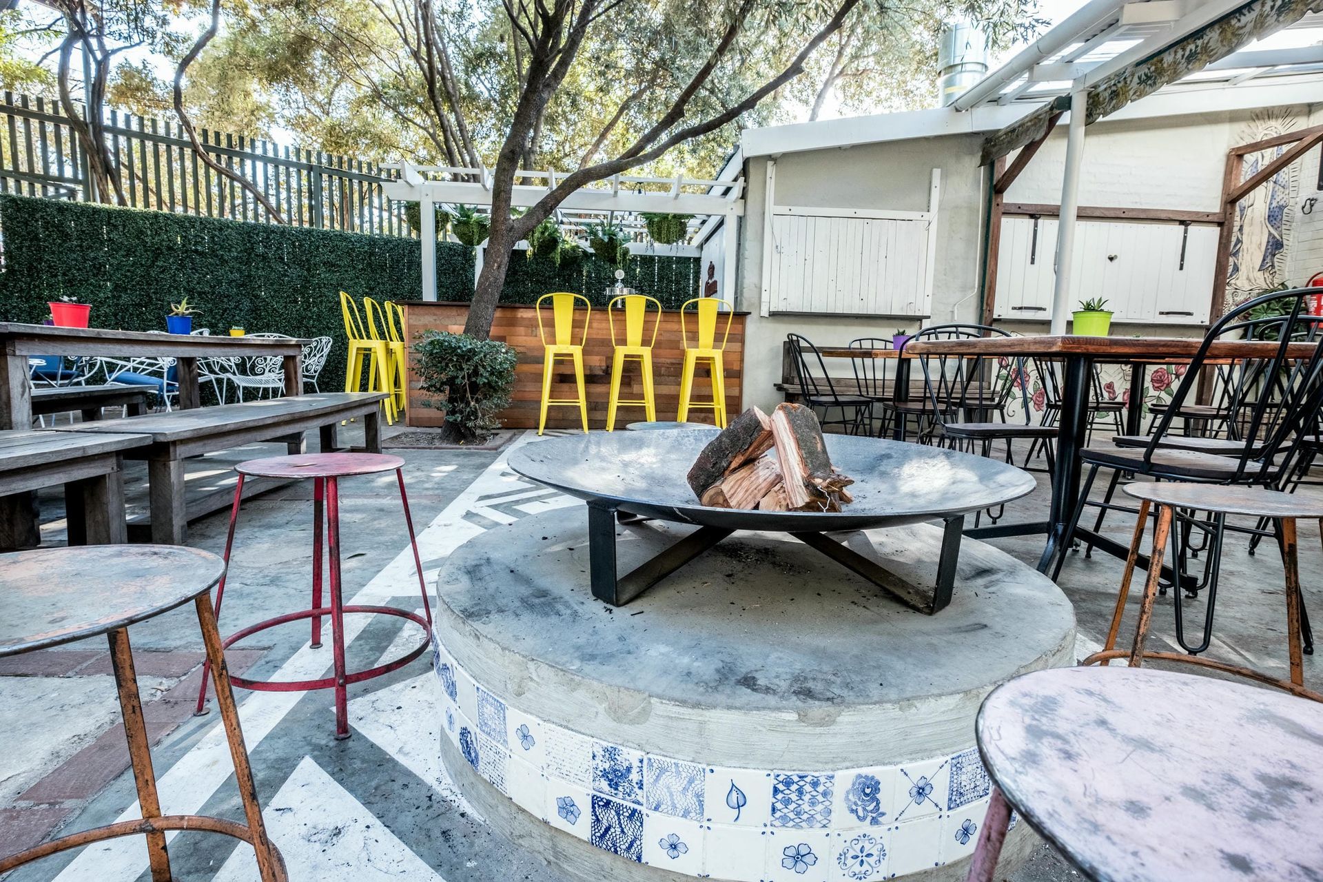 A fire pit is surrounded by tables and chairs in a restaurant.