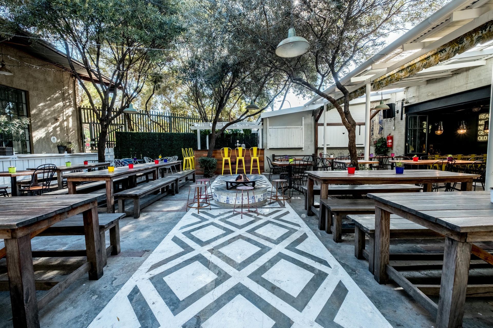 A restaurant with tables and benches in a courtyard.