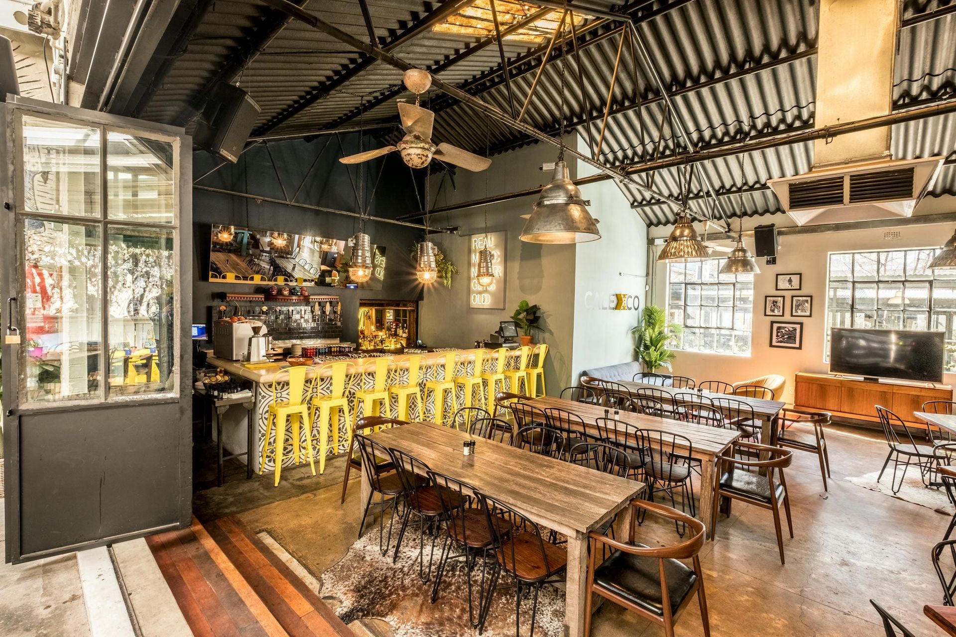 A restaurant with a lot of tables and chairs and a bar.