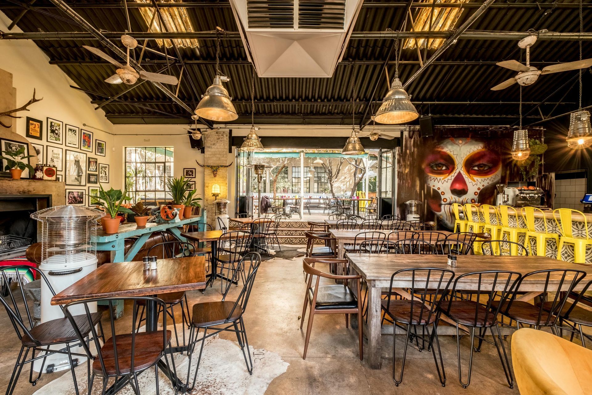 A restaurant with tables and chairs and a mural on the wall.