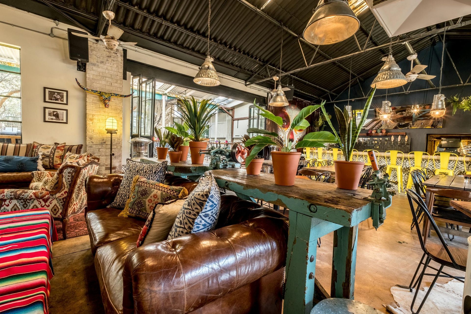 A restaurant with a lot of furniture and potted plants.
