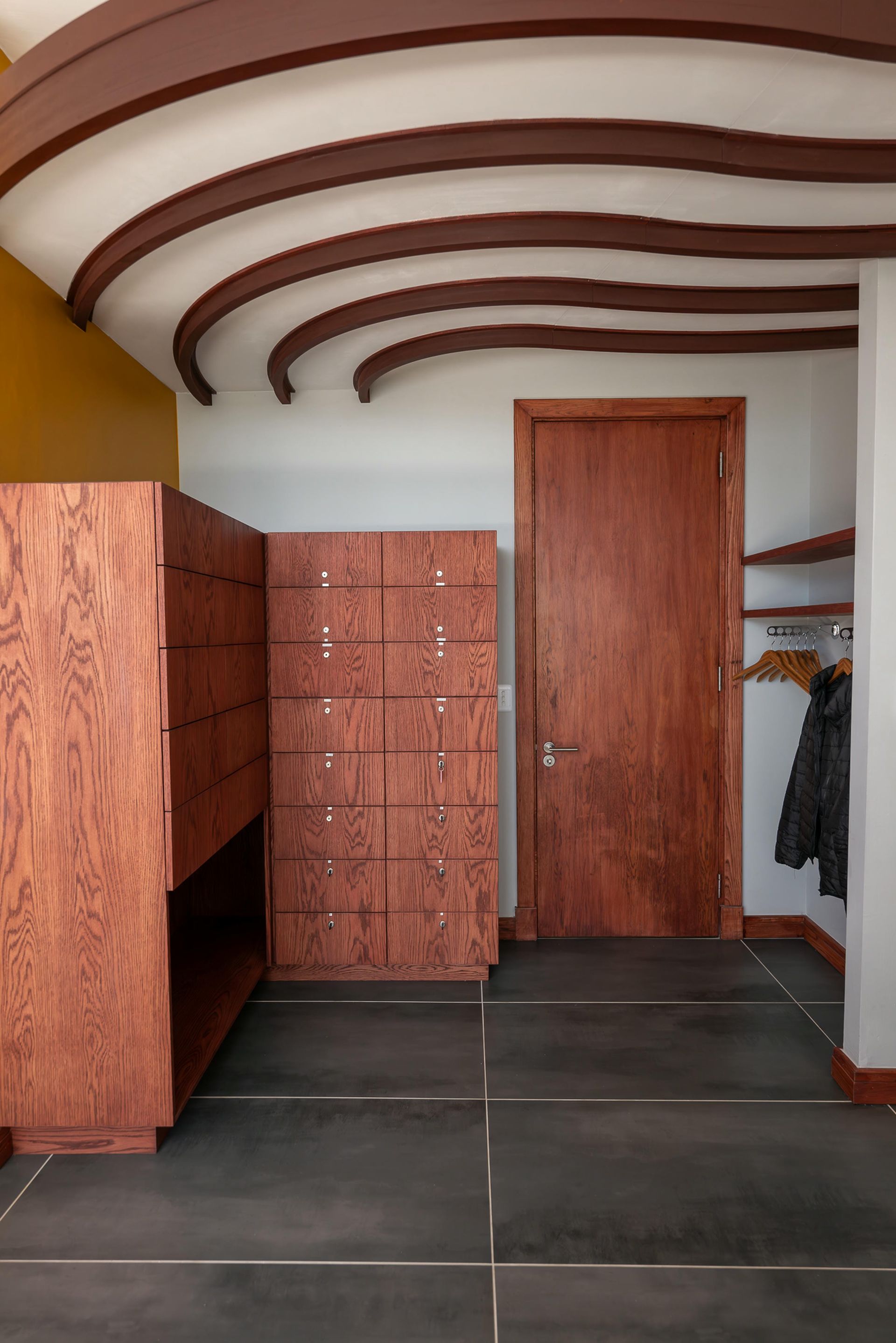 A walk in closet with wooden cabinets and a wooden door.