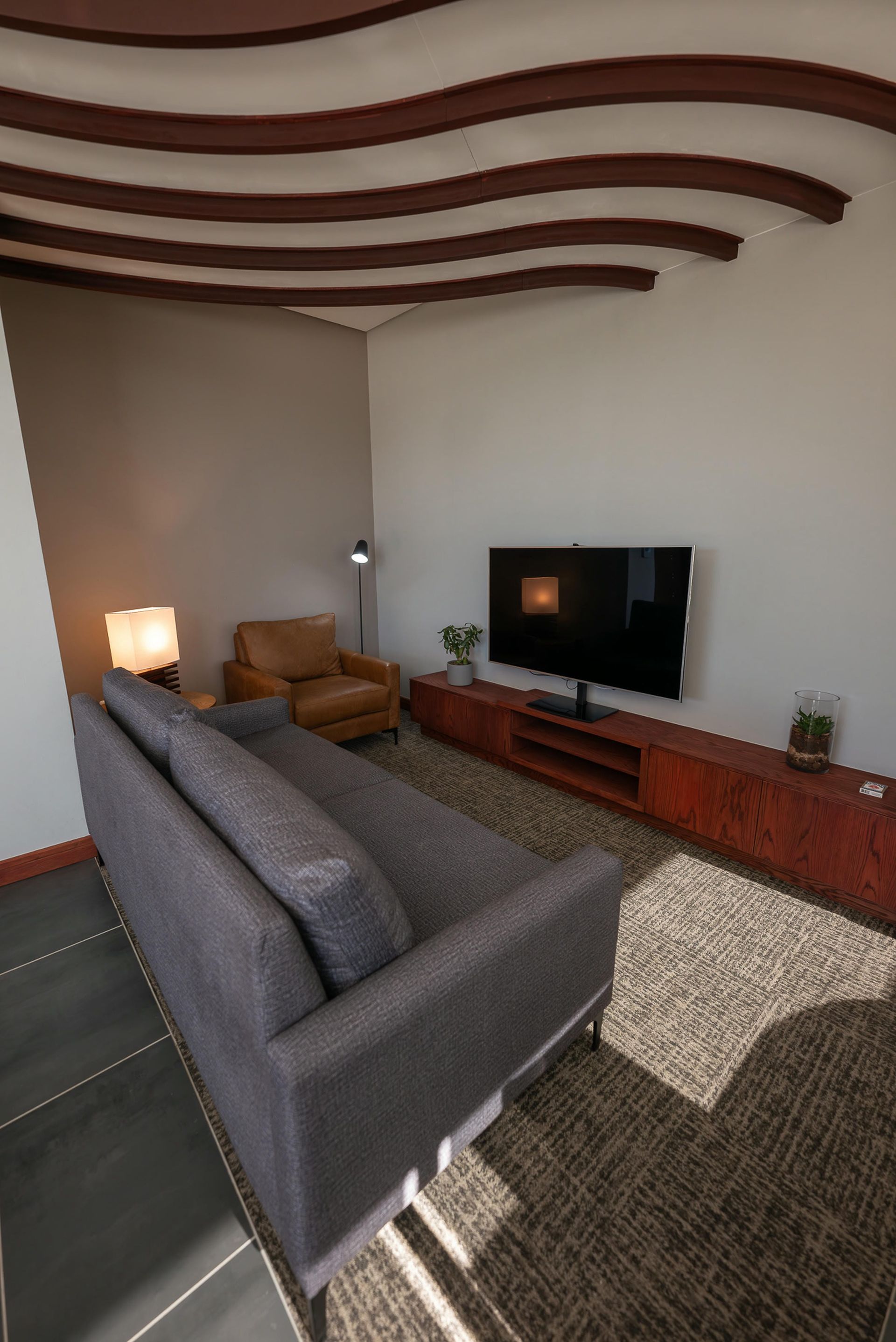 A living room with a couch , chair , and television.