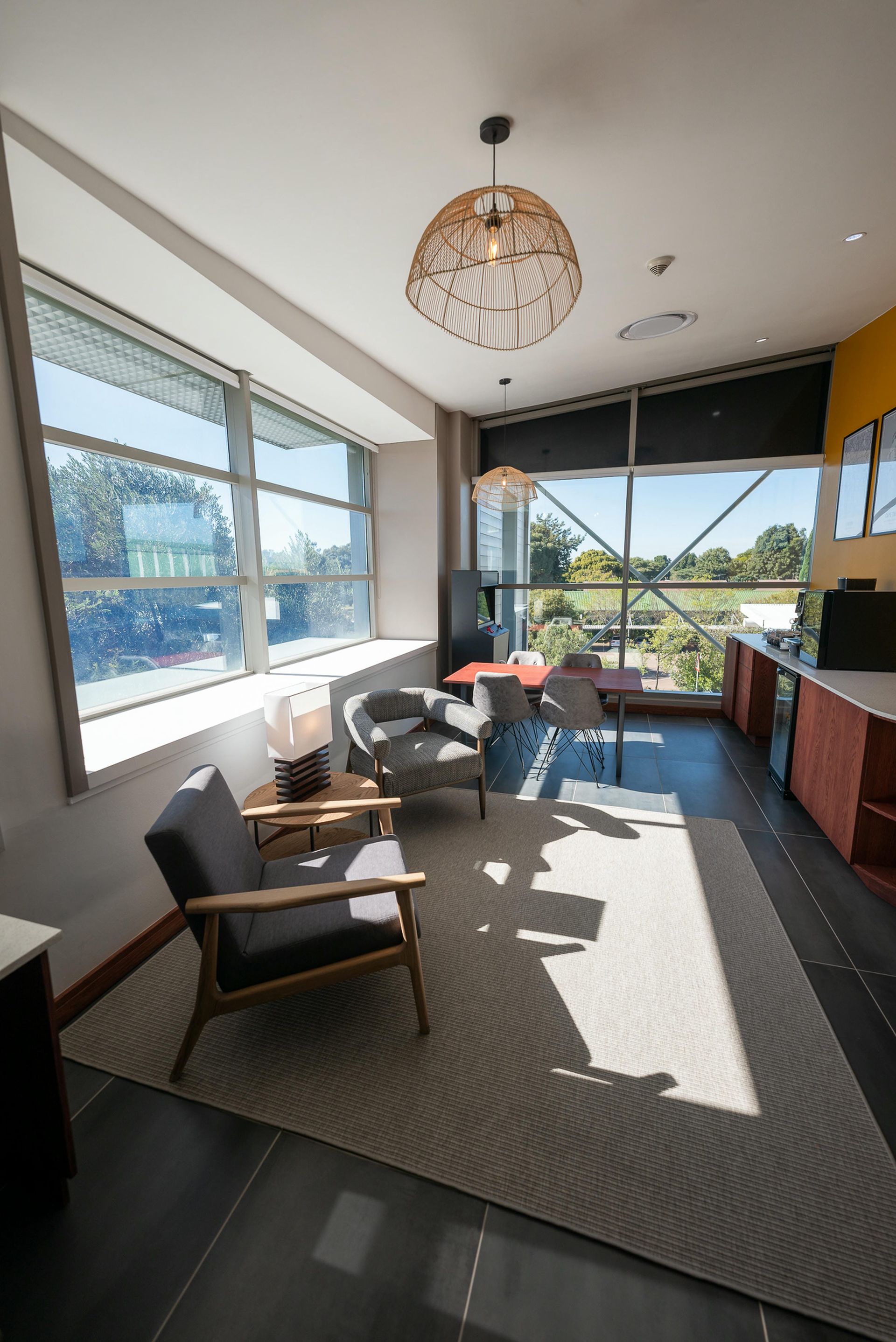 A living room with a lot of windows and chairs.