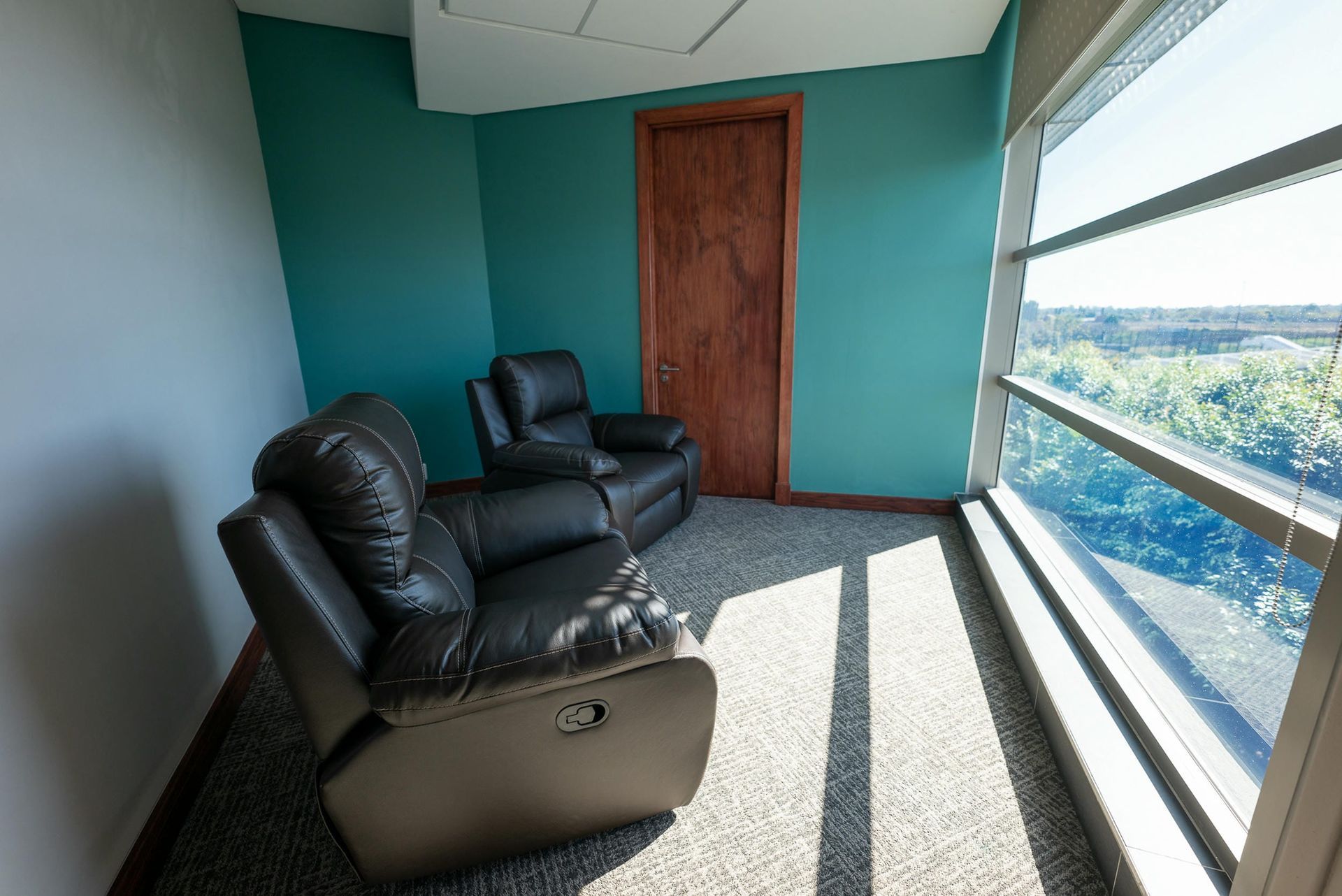 A room with two chairs and a large window