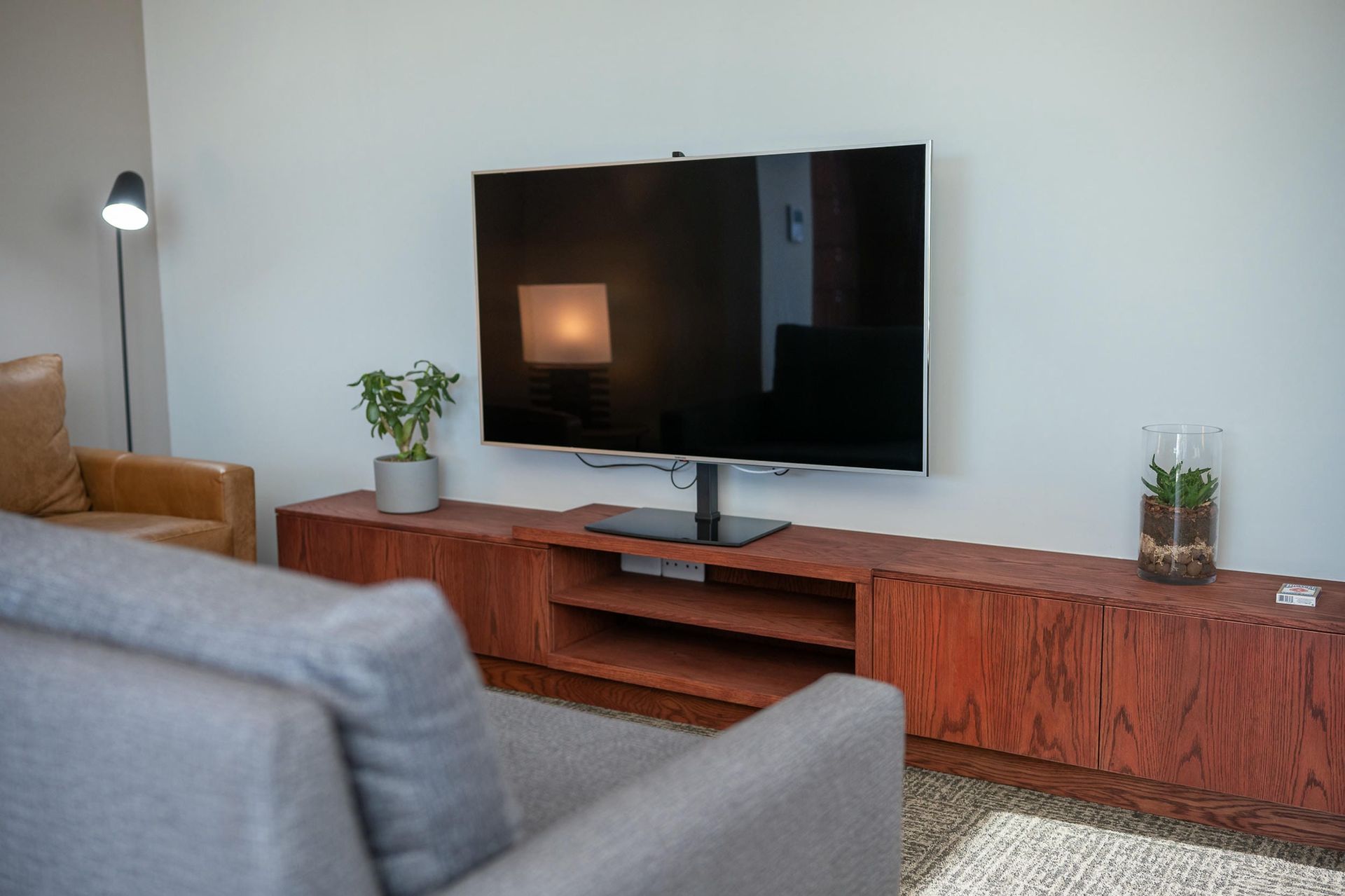 A living room with a couch , chair , and television.