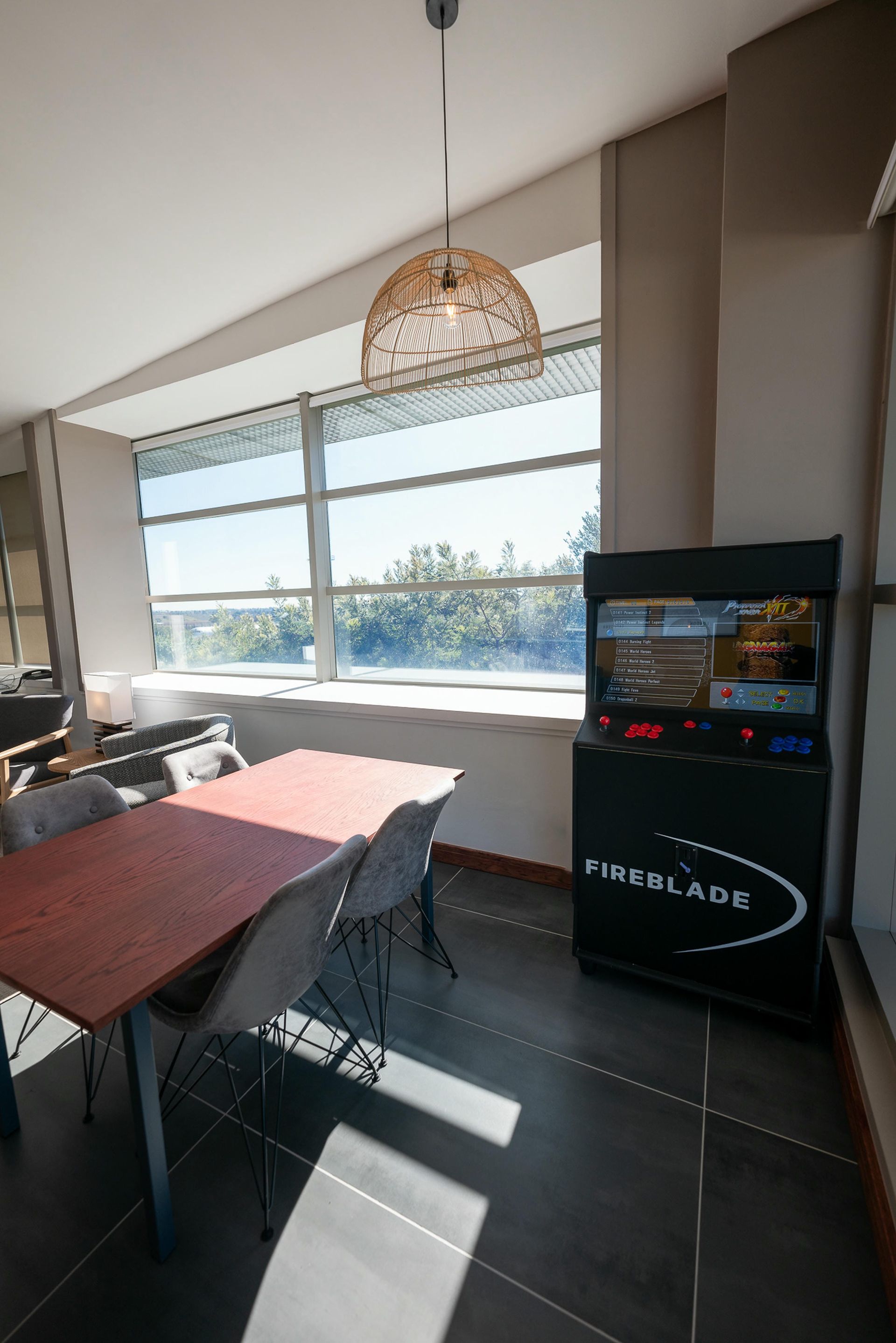 A room with a table and chairs and a video game machine.