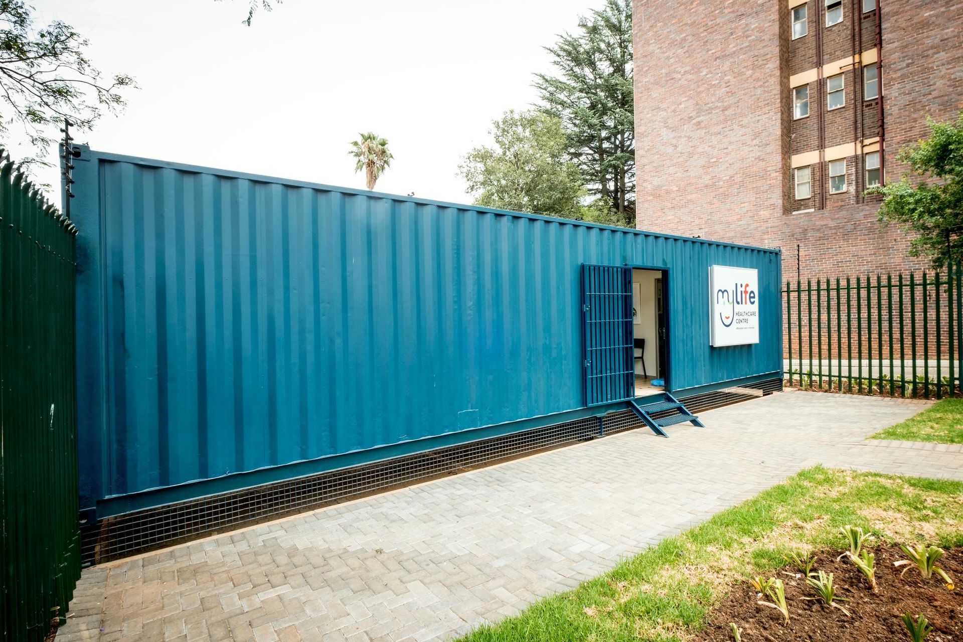 A blue shipping container with stairs leading up to it