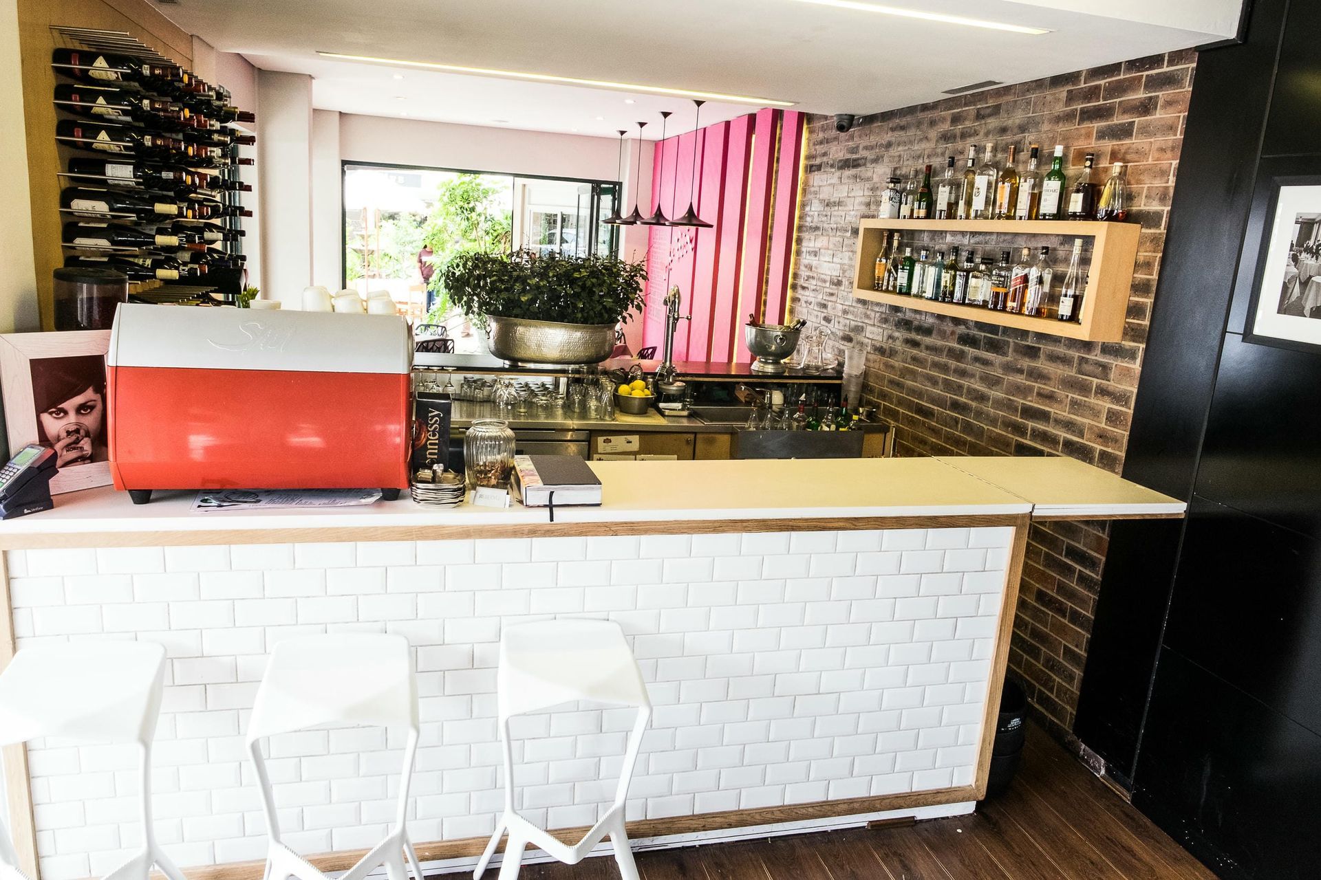 A bar with a red coffee machine and a brick wall