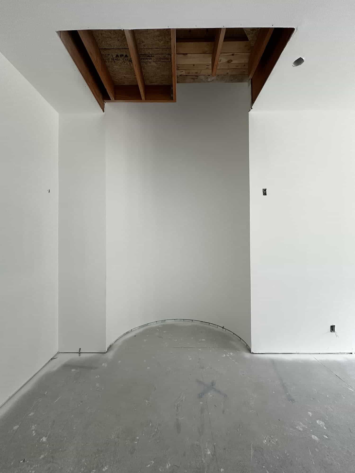 An empty room with white walls and a wooden ceiling