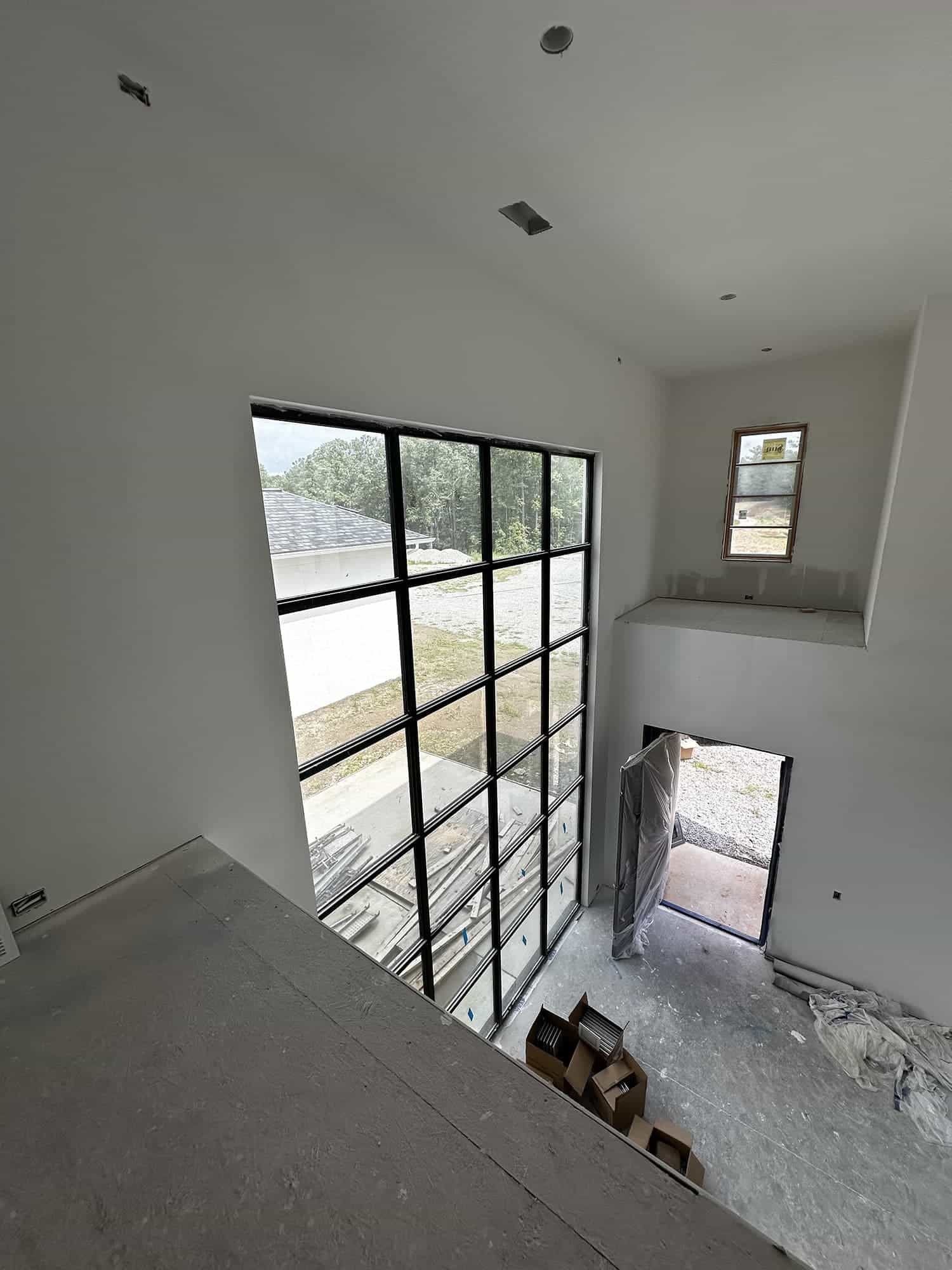 A man is standing in a room with a lot of windows.