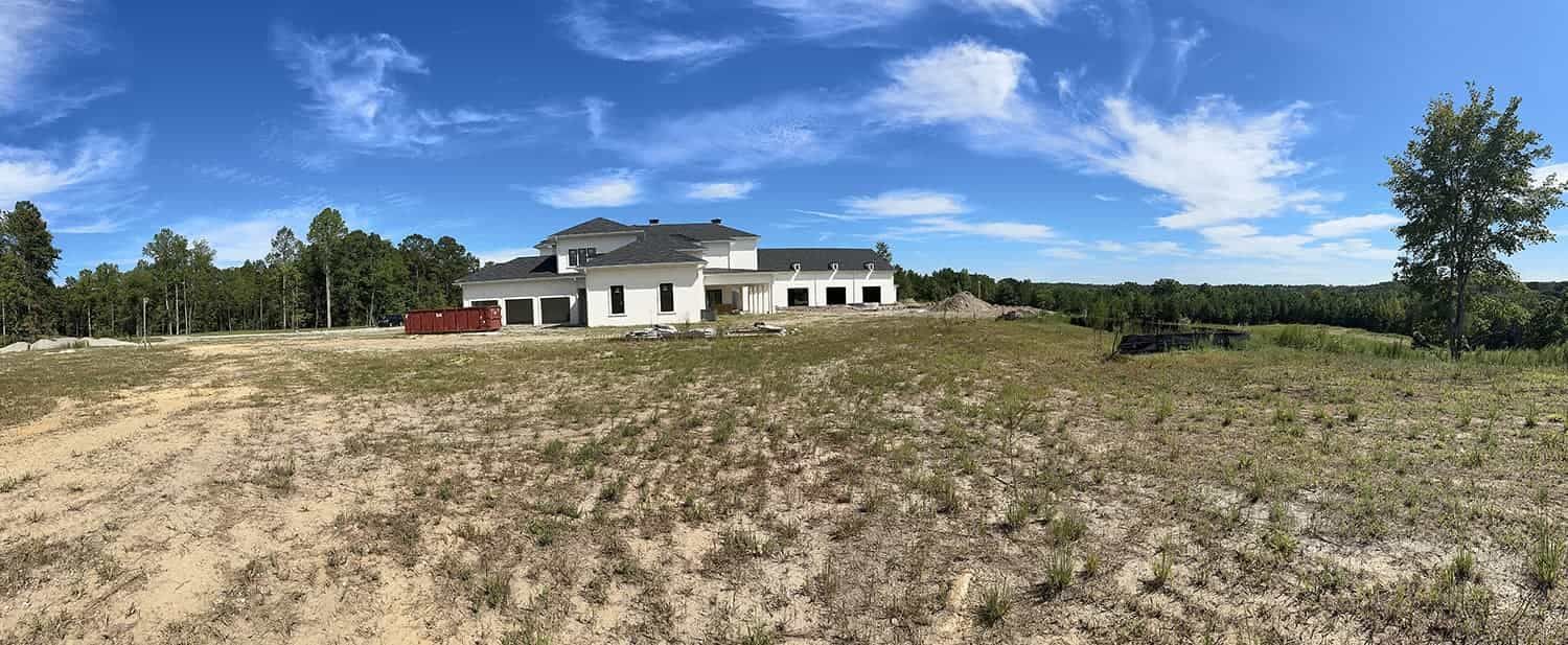 A large house is sitting in the middle of a field.
