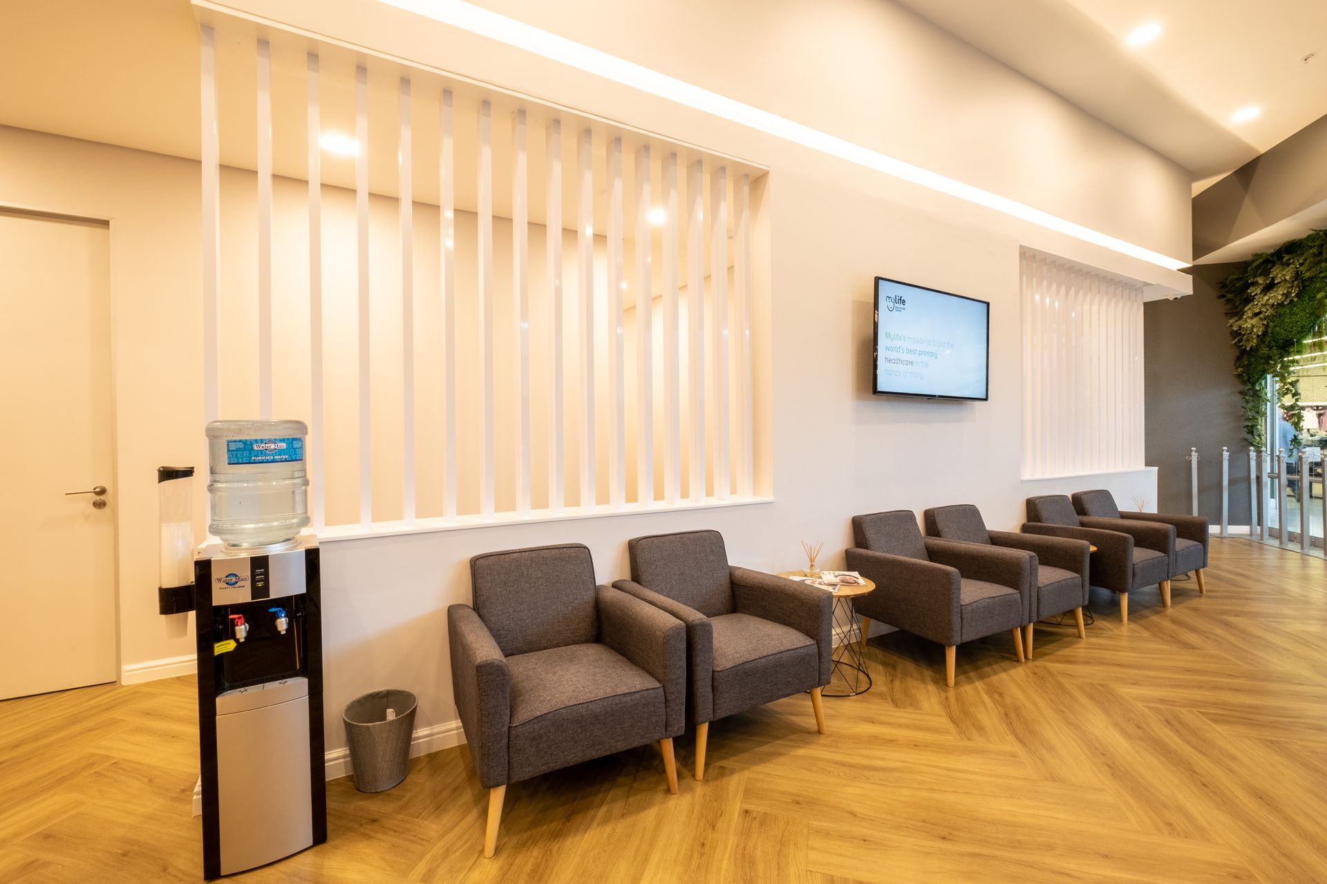A waiting room with chairs and a television on the wall.