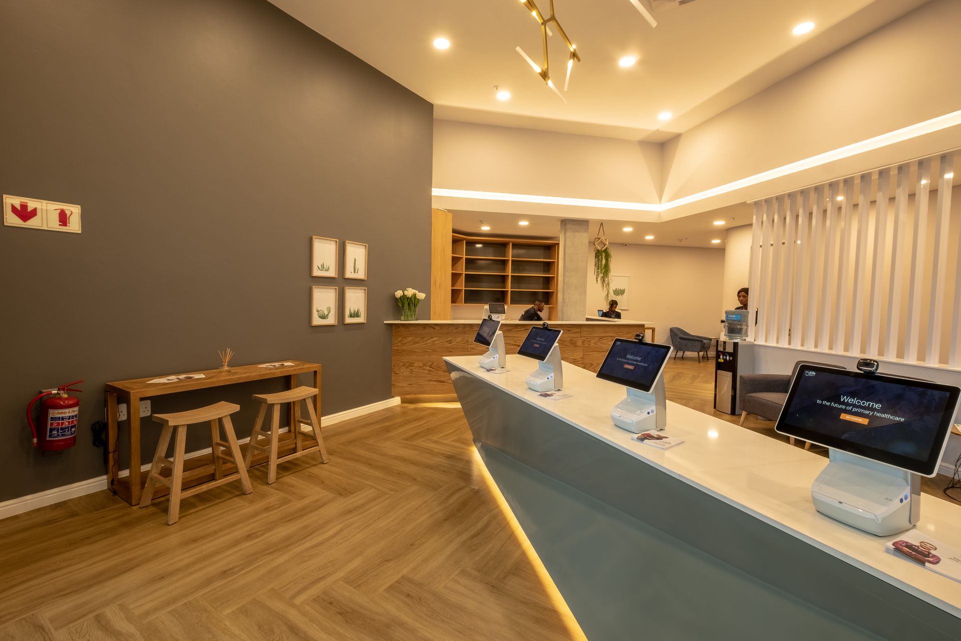 A reception area with a row of computers and stools.