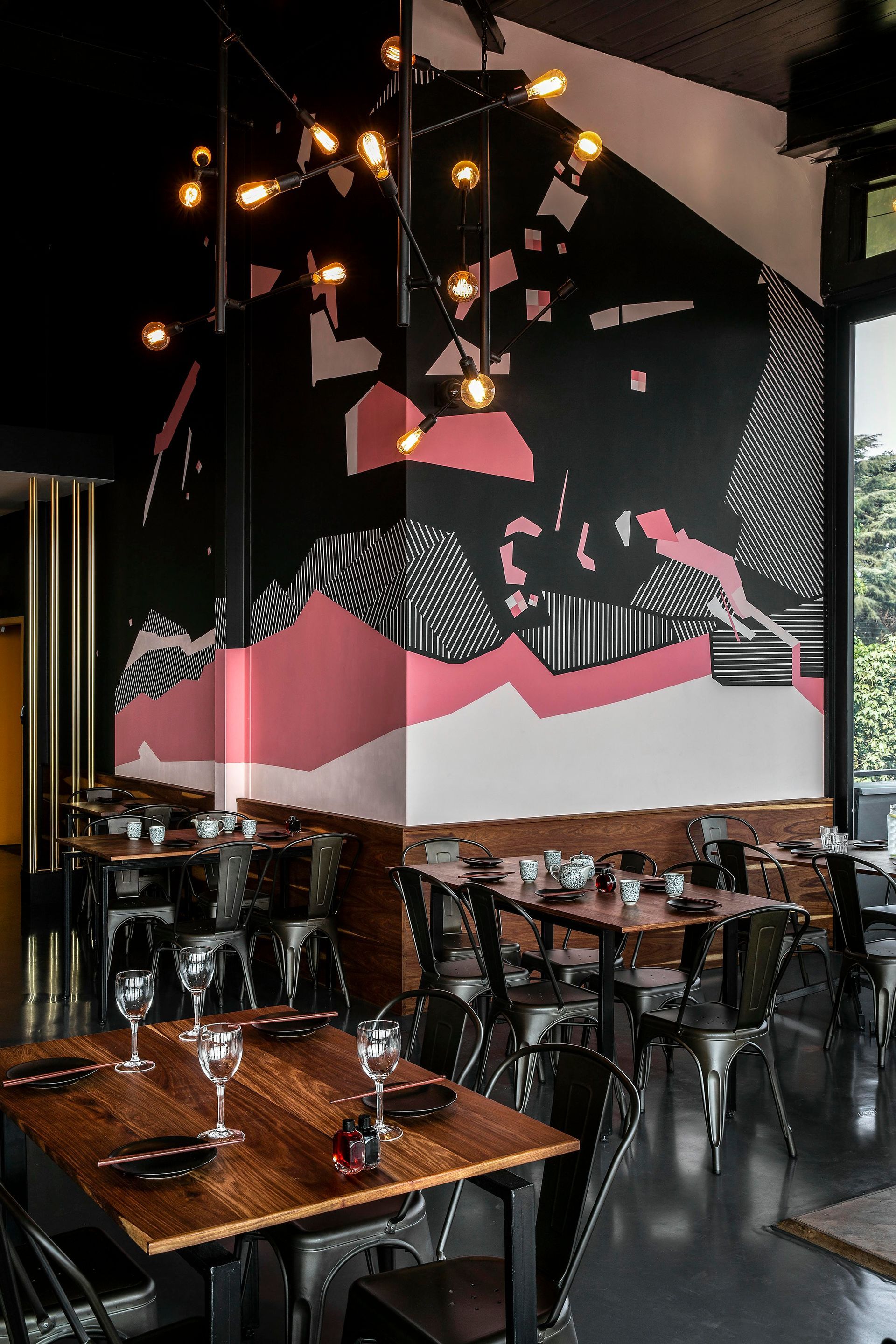 A restaurant with tables and chairs and a mural on the wall.