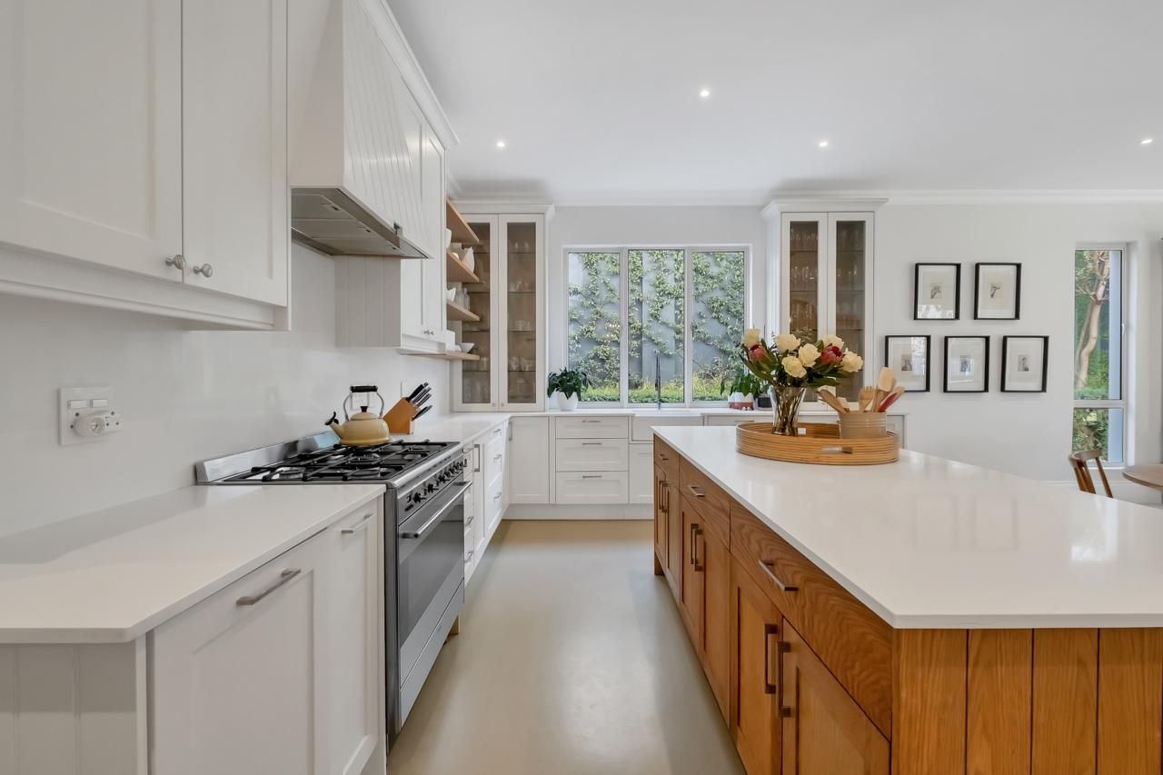 A kitchen with white cabinets and a large island in the middle.