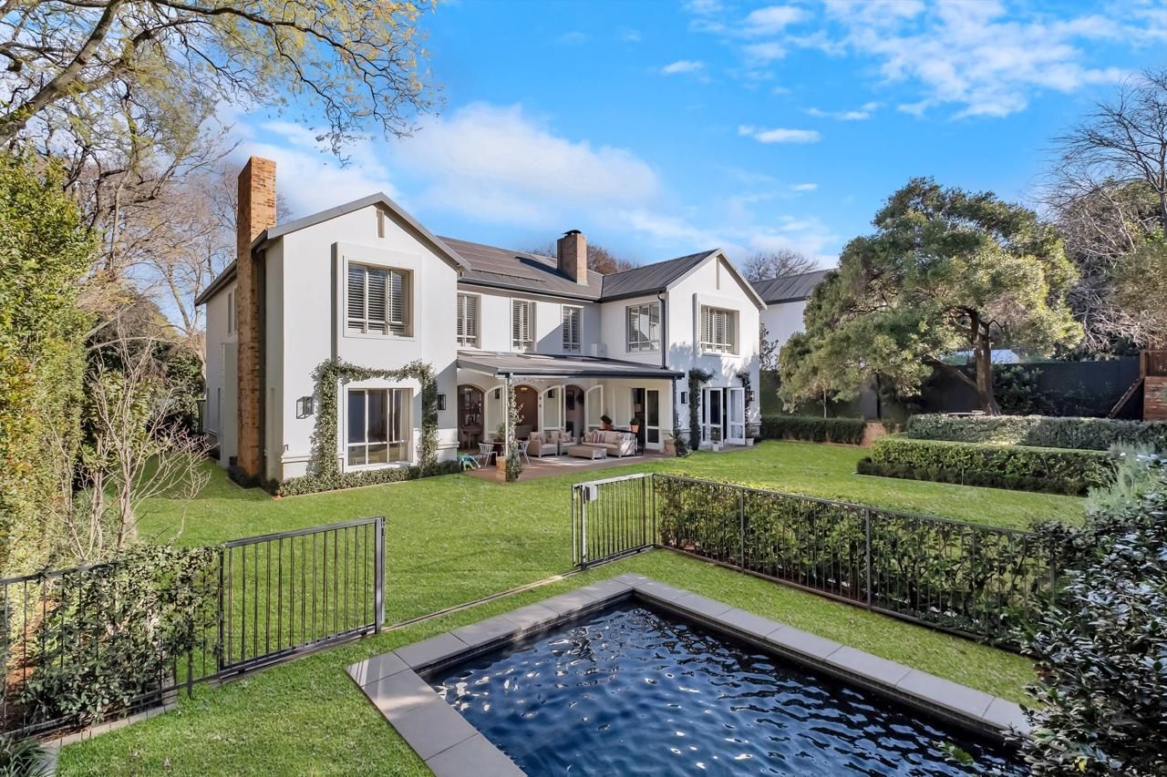 A large house with a swimming pool in front of it.