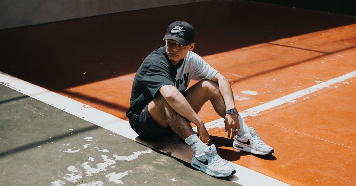 A man is sitting on the side of a tennis court.
