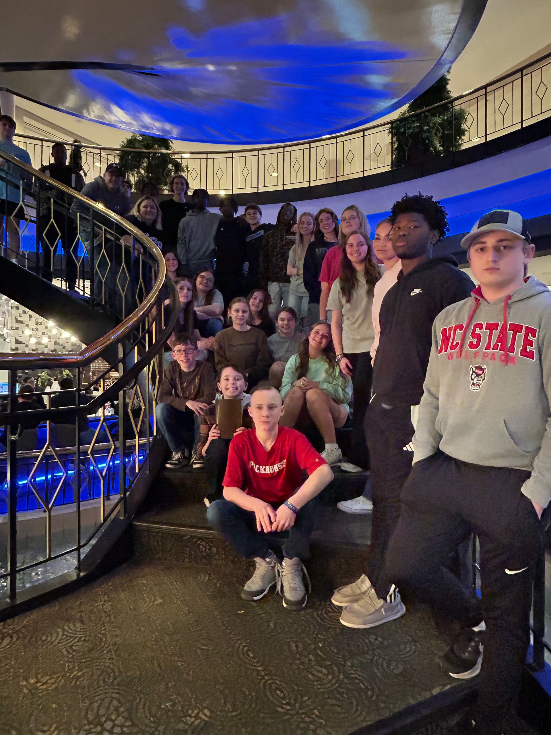 A group of people standing in front of a restaurant called delicious memories