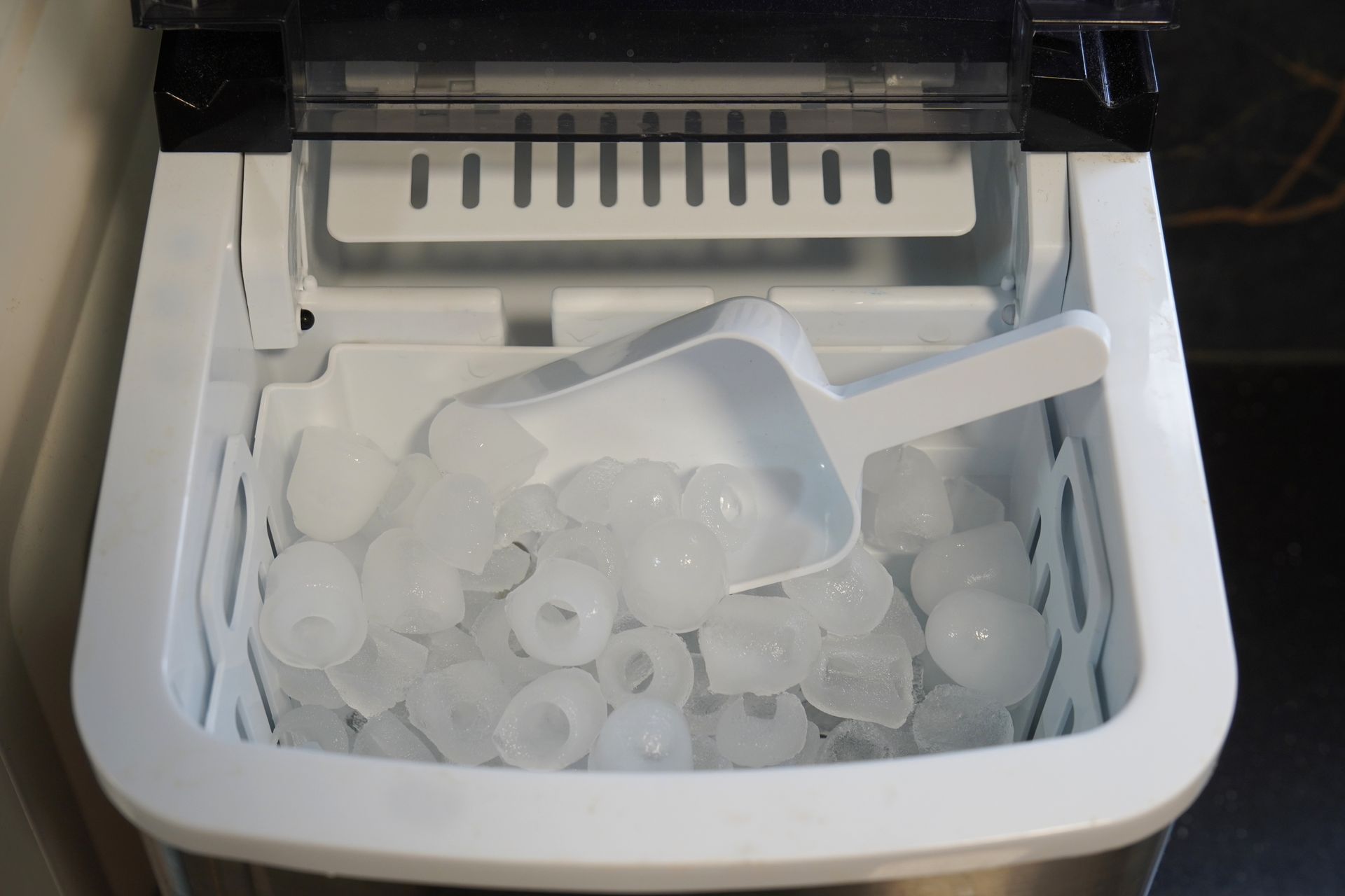 Ice maker with ice scoop and a bin full of ice. Ice maker with ice scoop and a bin full of ice.